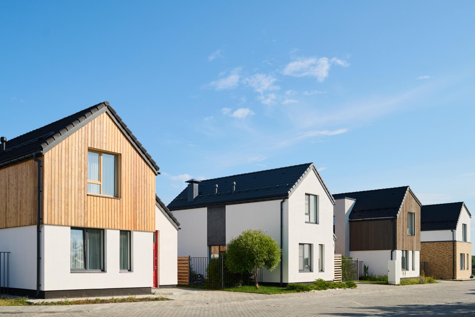 En rad av nyproducerade moderna bostadshus i ett nytt område, ett storskaligt entreprenad-projekt.