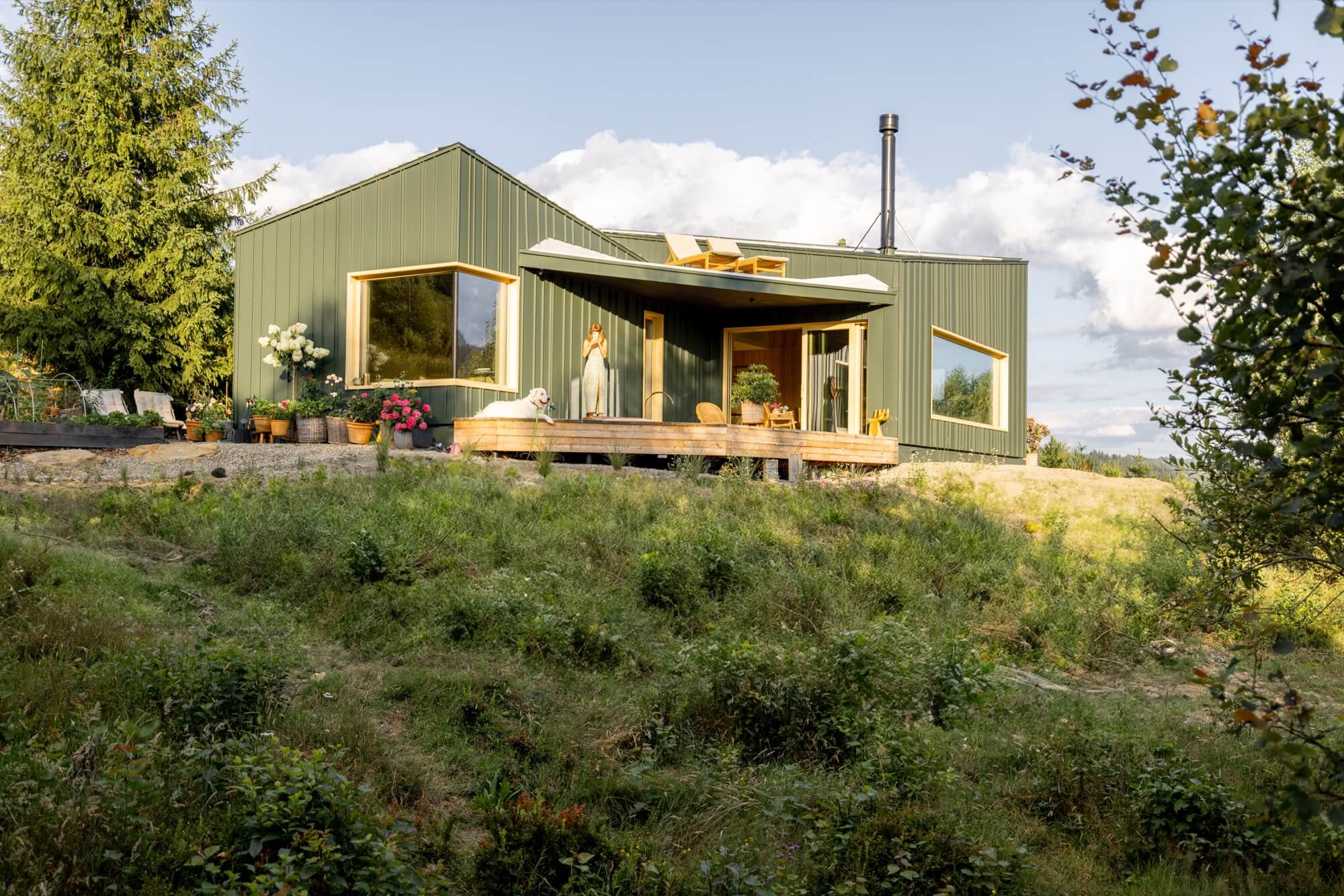 En modern, grön villa belägen i naturen, ett exempel på en skräddarsydd entreprenad för ett unikt boende.